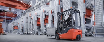 toyota traigo24 electric forklift truck carrying a pallet through a warehouse