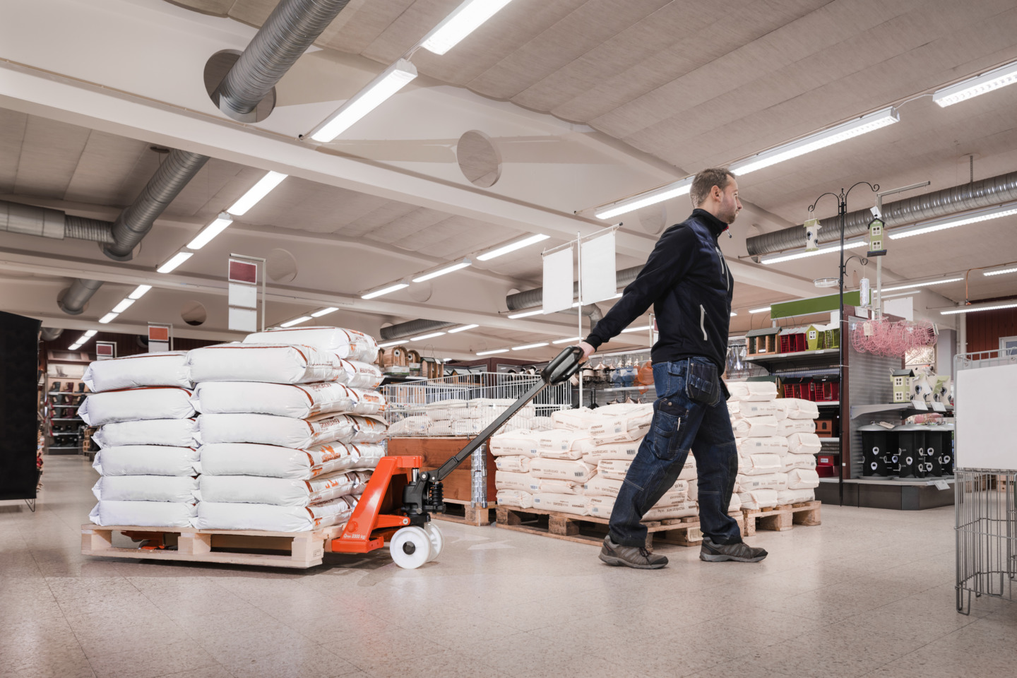 a hand pallet truck being dragged through a retail shop floor